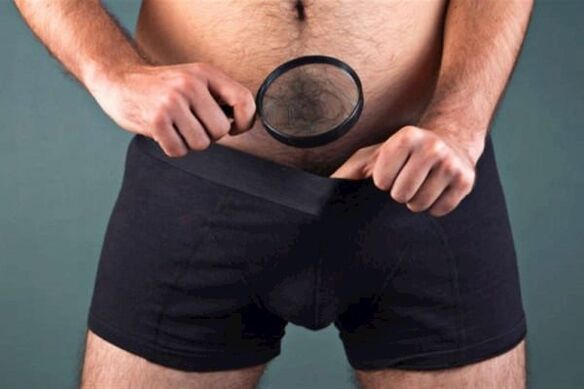a man with a magnifying glass examines his penis and wants to enlarge it